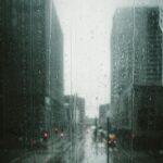 Moody view of a rainy day in Minneapolis, capturing the urban scene through a glass window with raindrops.